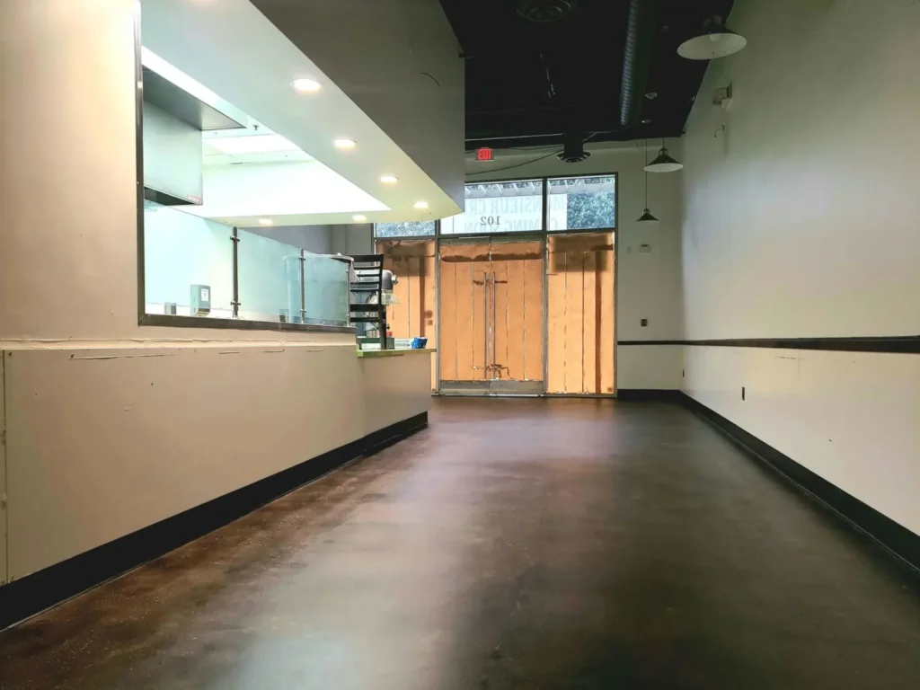 Dark decorative resin floor beside a service counter in a commercial interior.