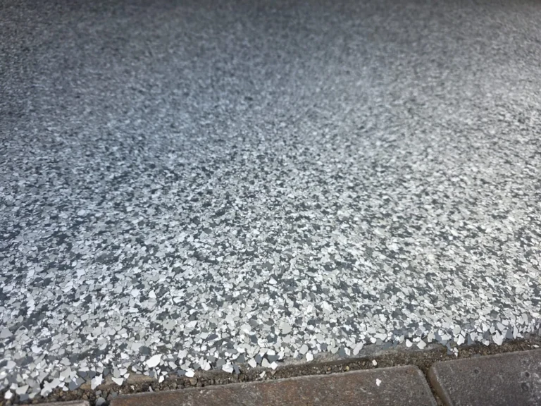 Close view of a grey decorative flake floor meeting a concrete threshold