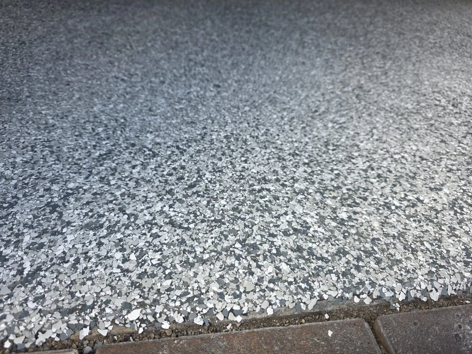 Polyaspartic clear coat threshold close-up over decorative flake floor in Vancouver BC