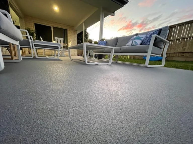 Grey textured coated patio beneath a covered outdoor seating area