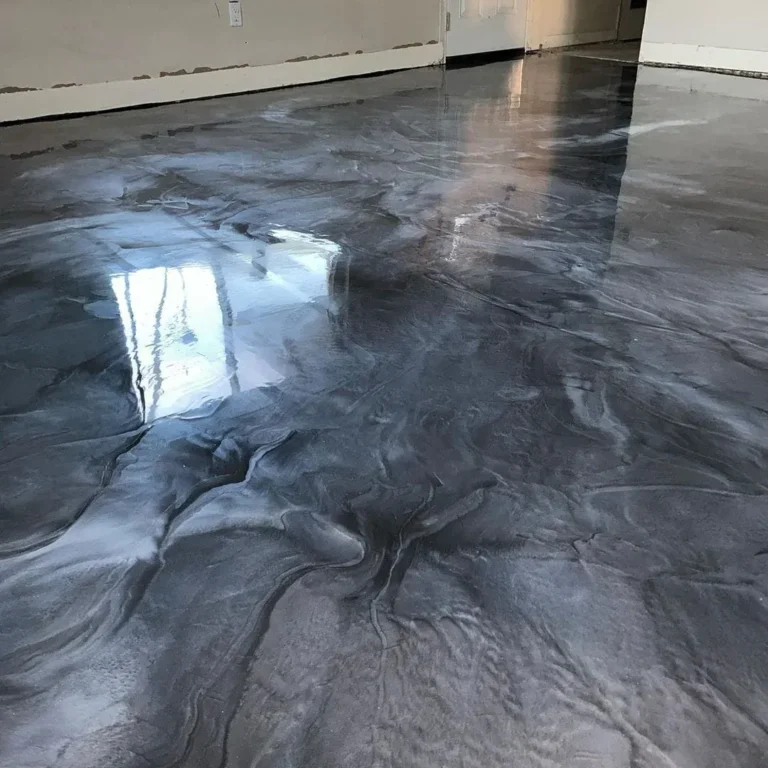 Charcoal and silver metallic epoxy floor with swirling patterns and reflected window light.