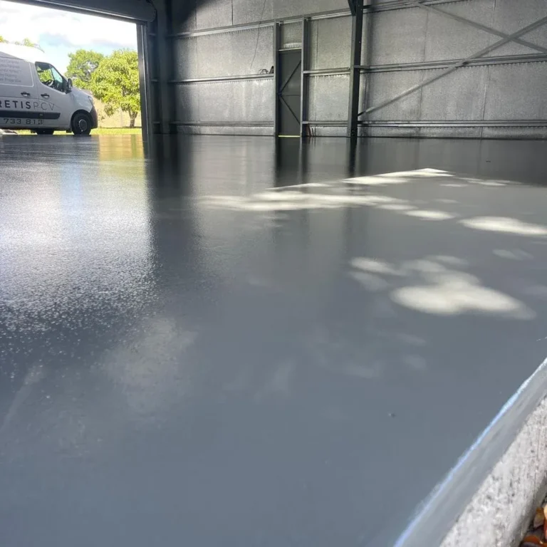 Solid grey floor coating near an open workshop doorway with daylight reflections.