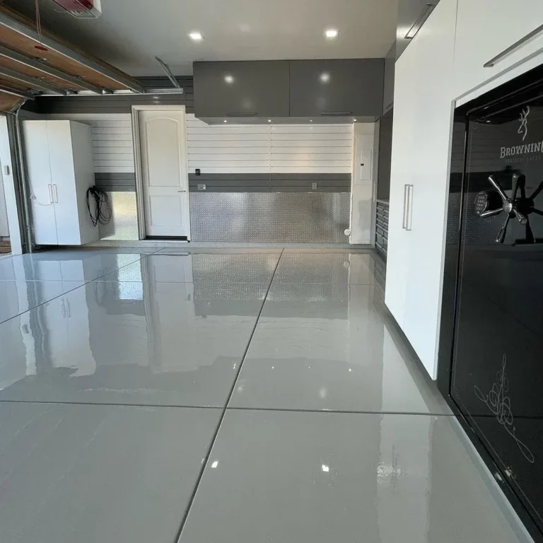 Glossy solid grey floor in a garage with overhead lighting reflected on the surface.