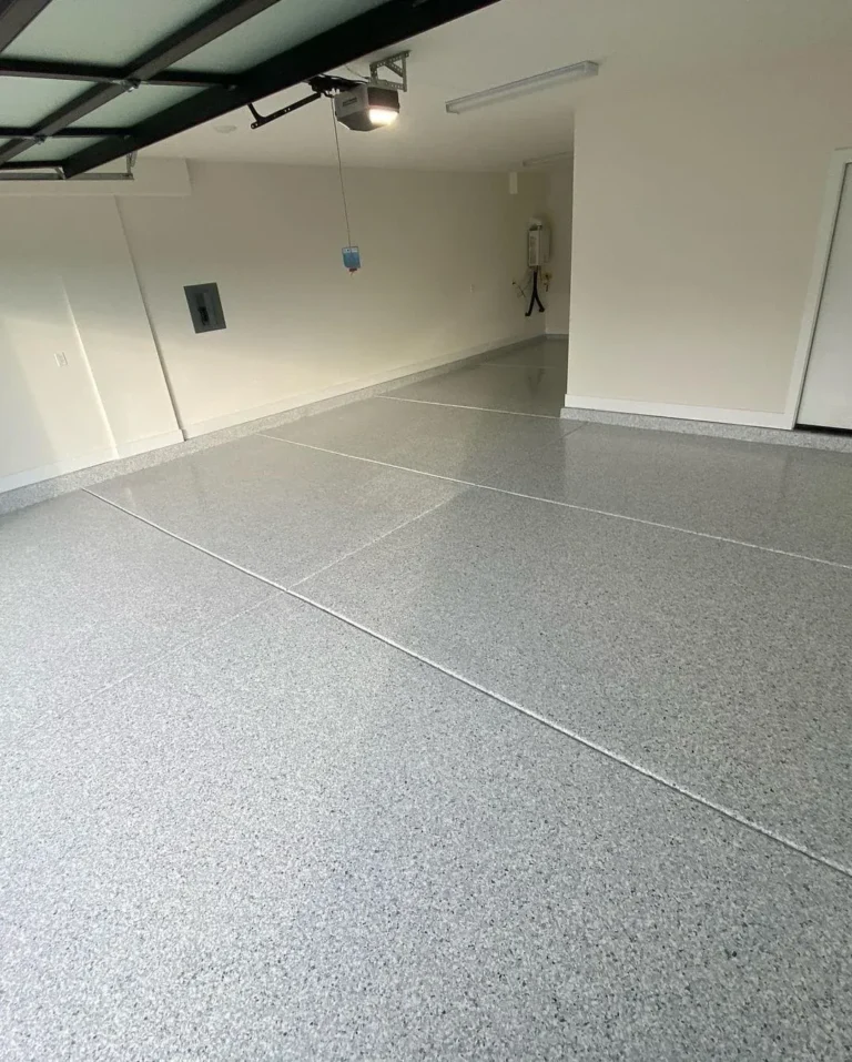 Light grey flake coating across a garage floor with visible control joints.