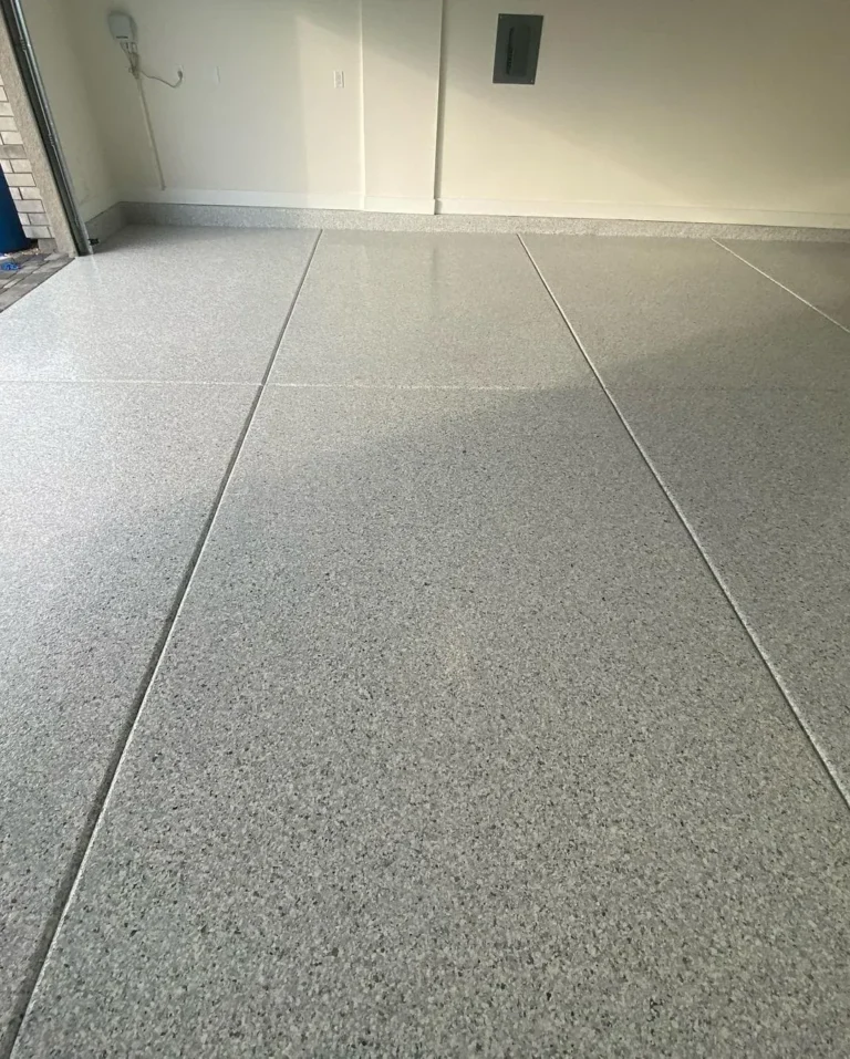 Close view of light grey flake flooring and intersecting garage floor joints.