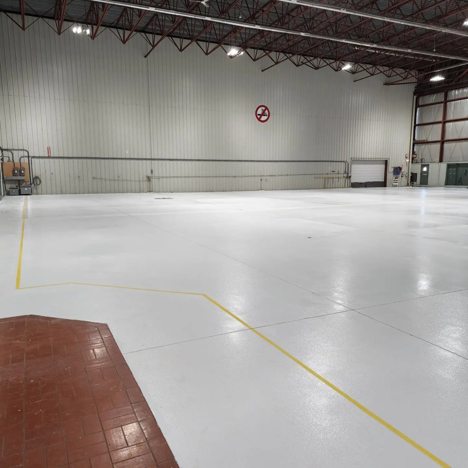 Finished aircraft hangar floor coating with yellow service line at YVR