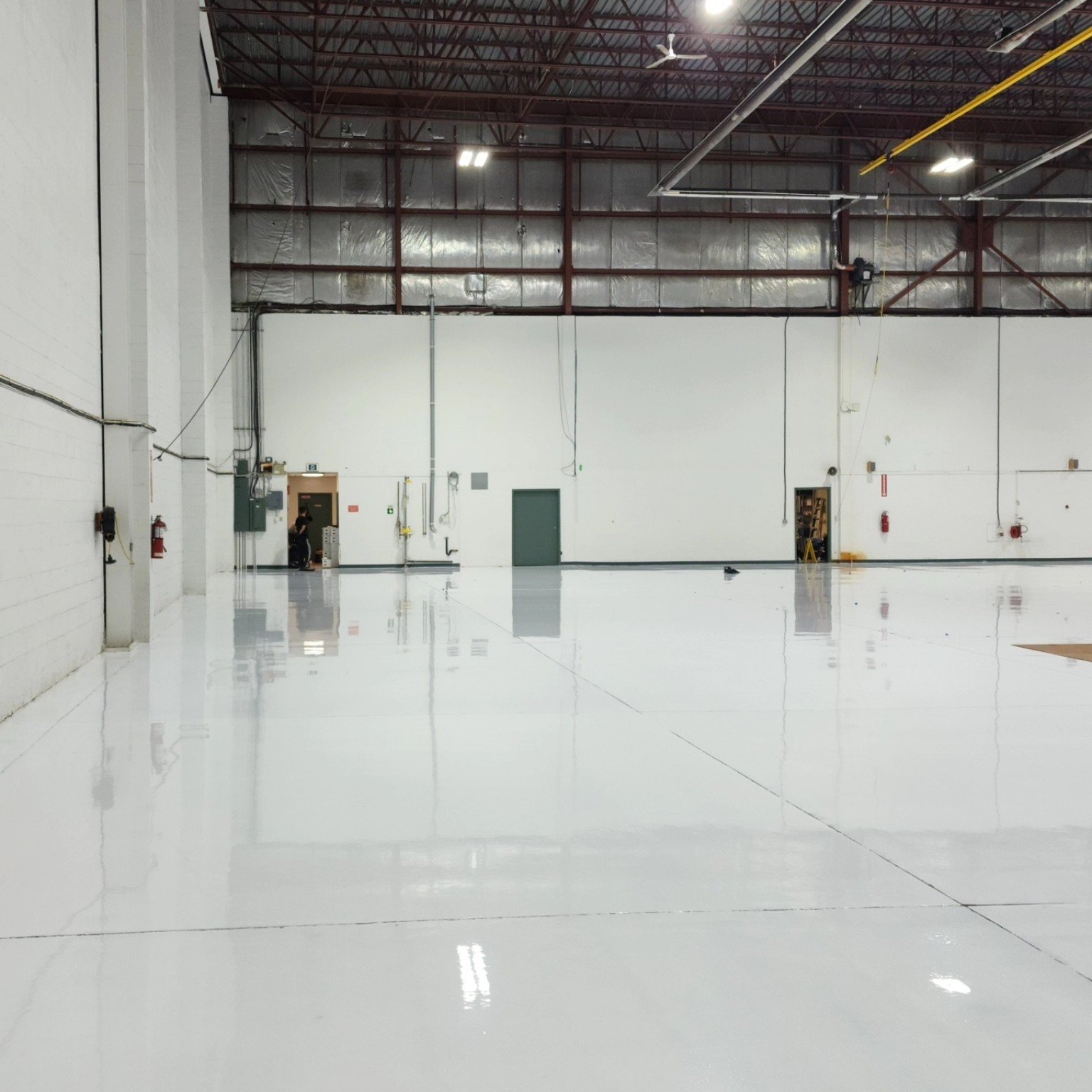 Light reflective finished resin flooring inside aircraft hangar at YVR