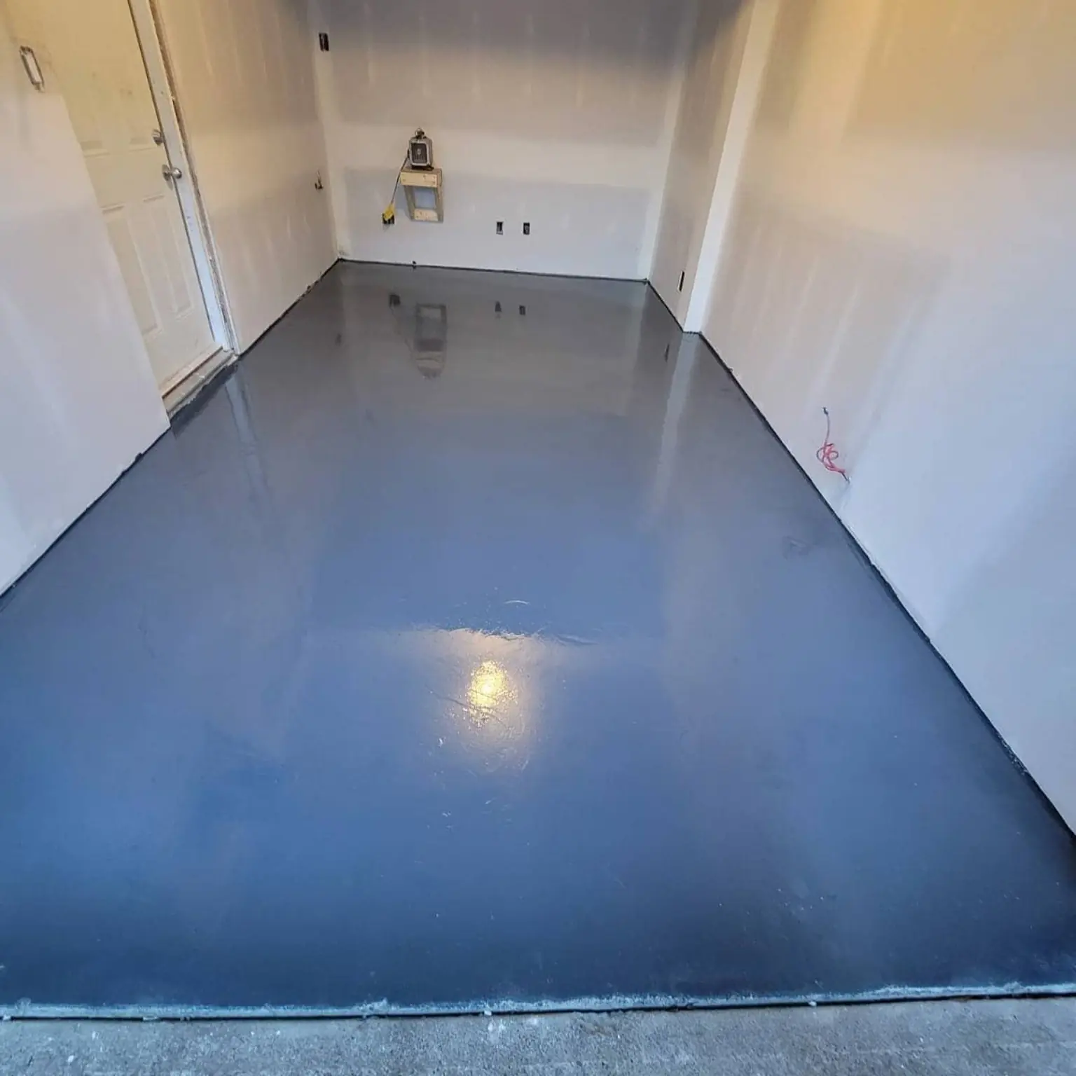 Blue-grey epoxy garage floor with a seamless glossy finish