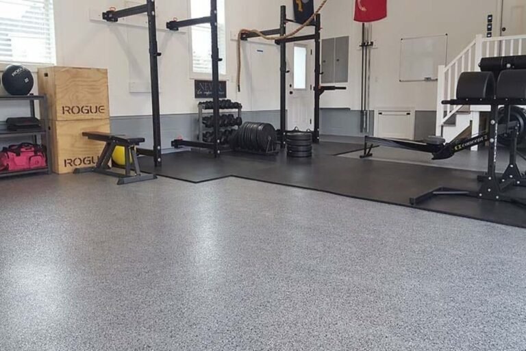 Grey flake garage floor beside rubber mats and home gym equipment