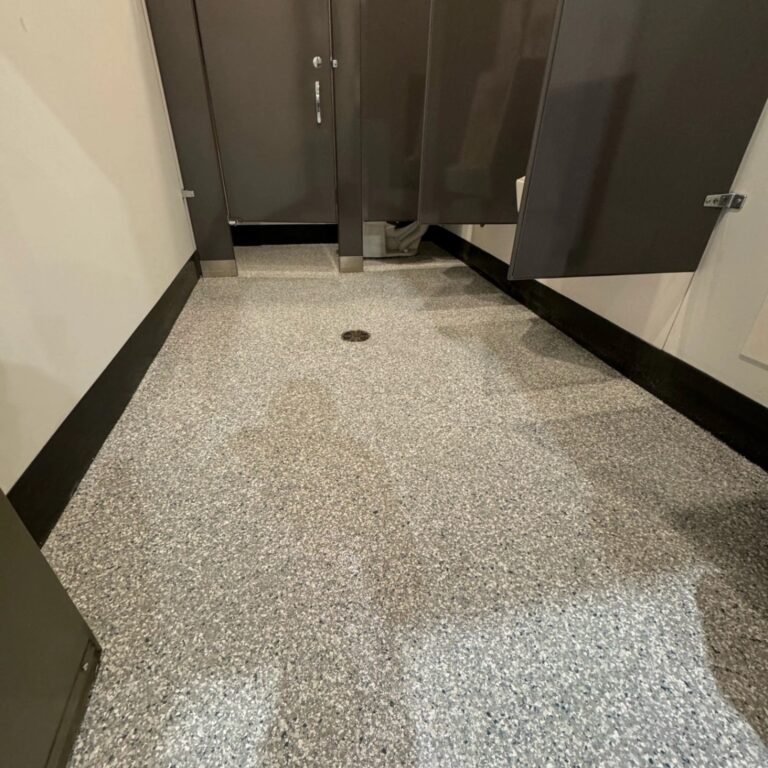 Completed grey flake resin floor with a floor drain in a Liebherr staff washroom in Abbotsford