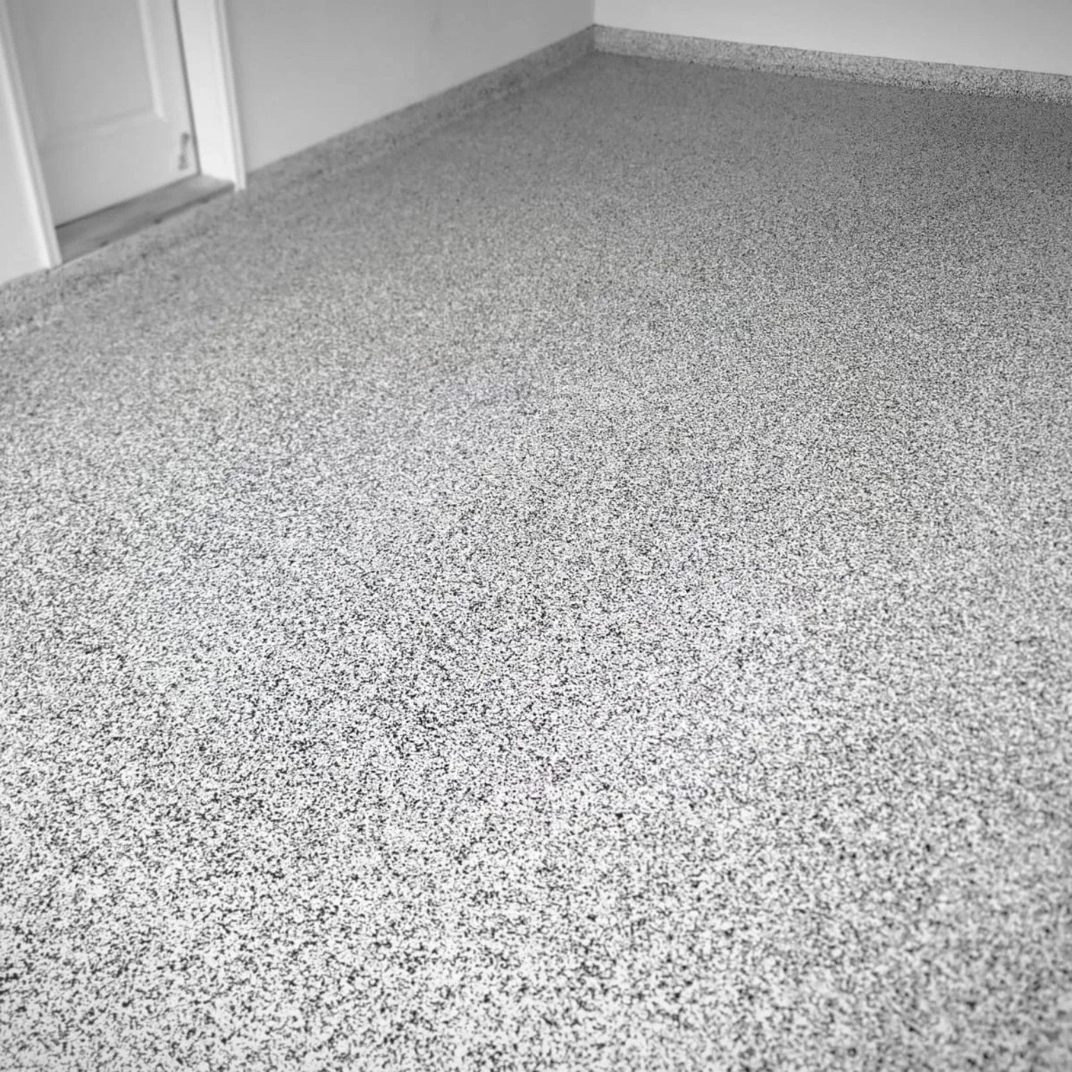 Grey flake epoxy garage flooring close-up texture in West Kelowna BC