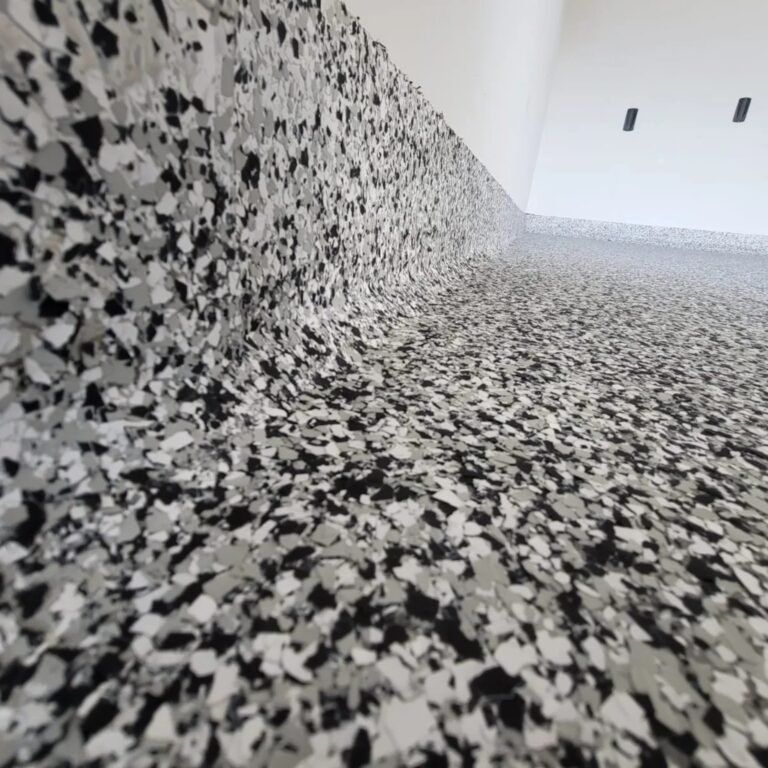 Coved flake-coated junction between the garage floor and wall