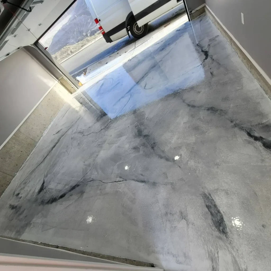 Silver and black marble-look metallic epoxy floor at a garage entrance