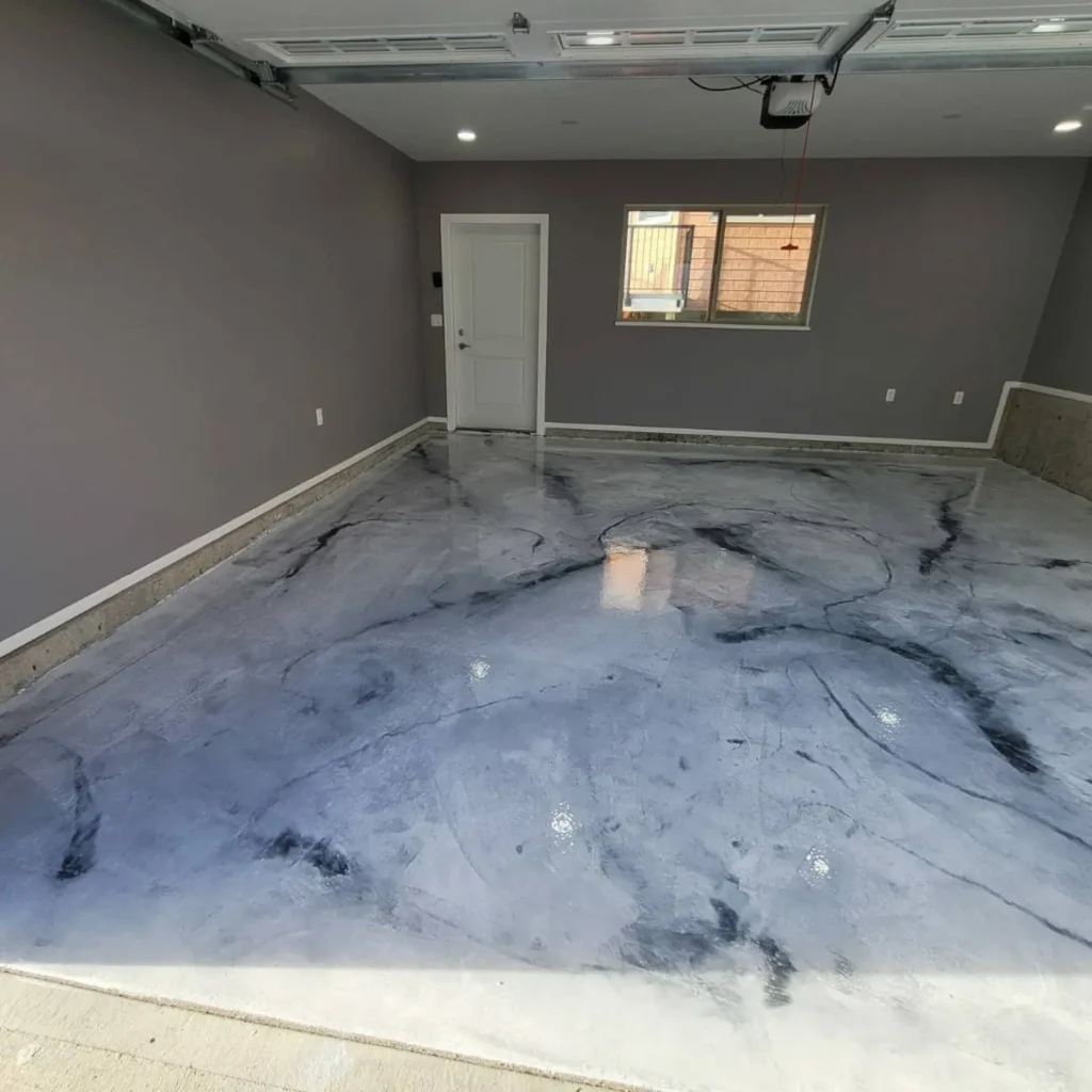 Silver and charcoal metallic epoxy floor inside a garage with an overhead door
