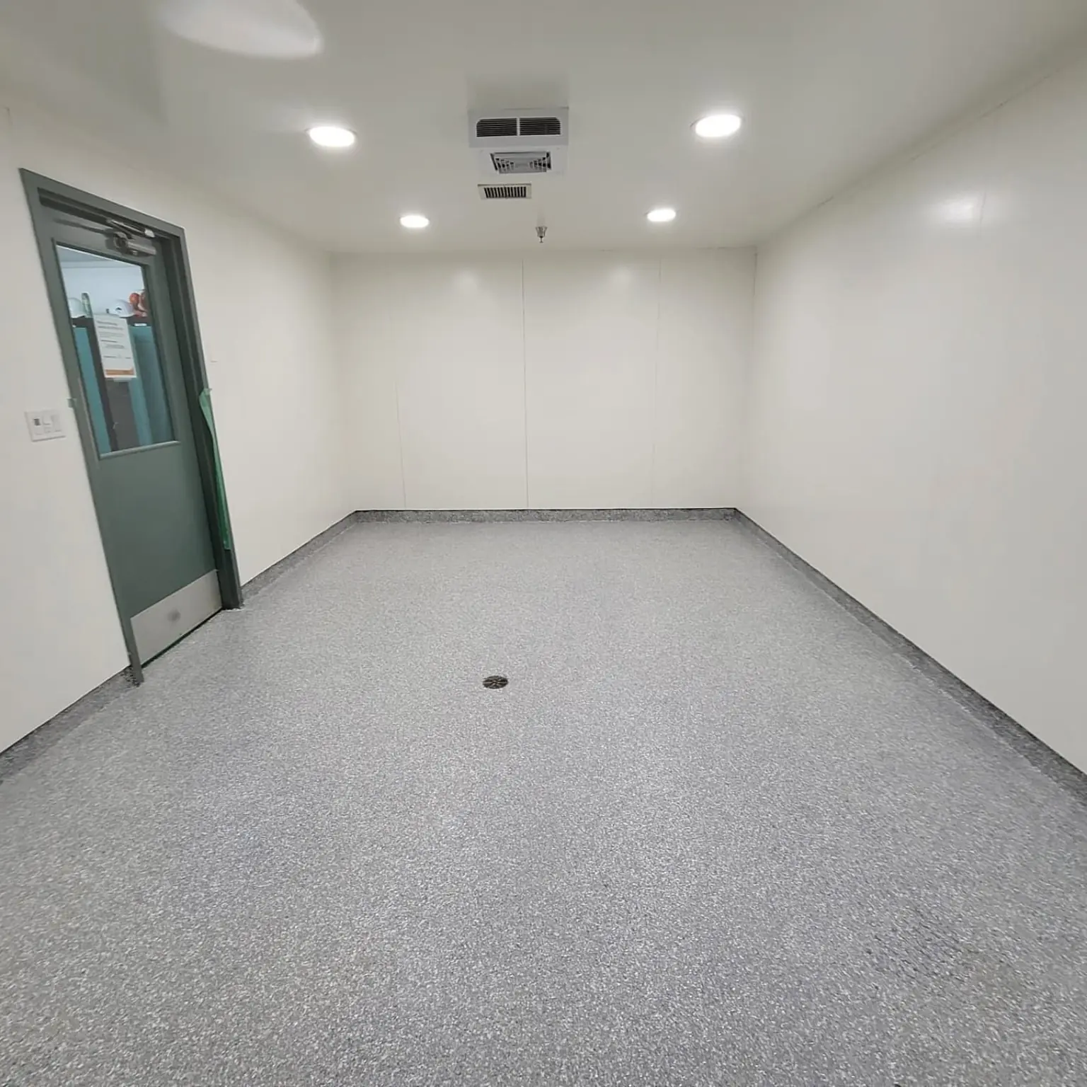 Completed urethane cement floor with drain in a Yaletown utility room